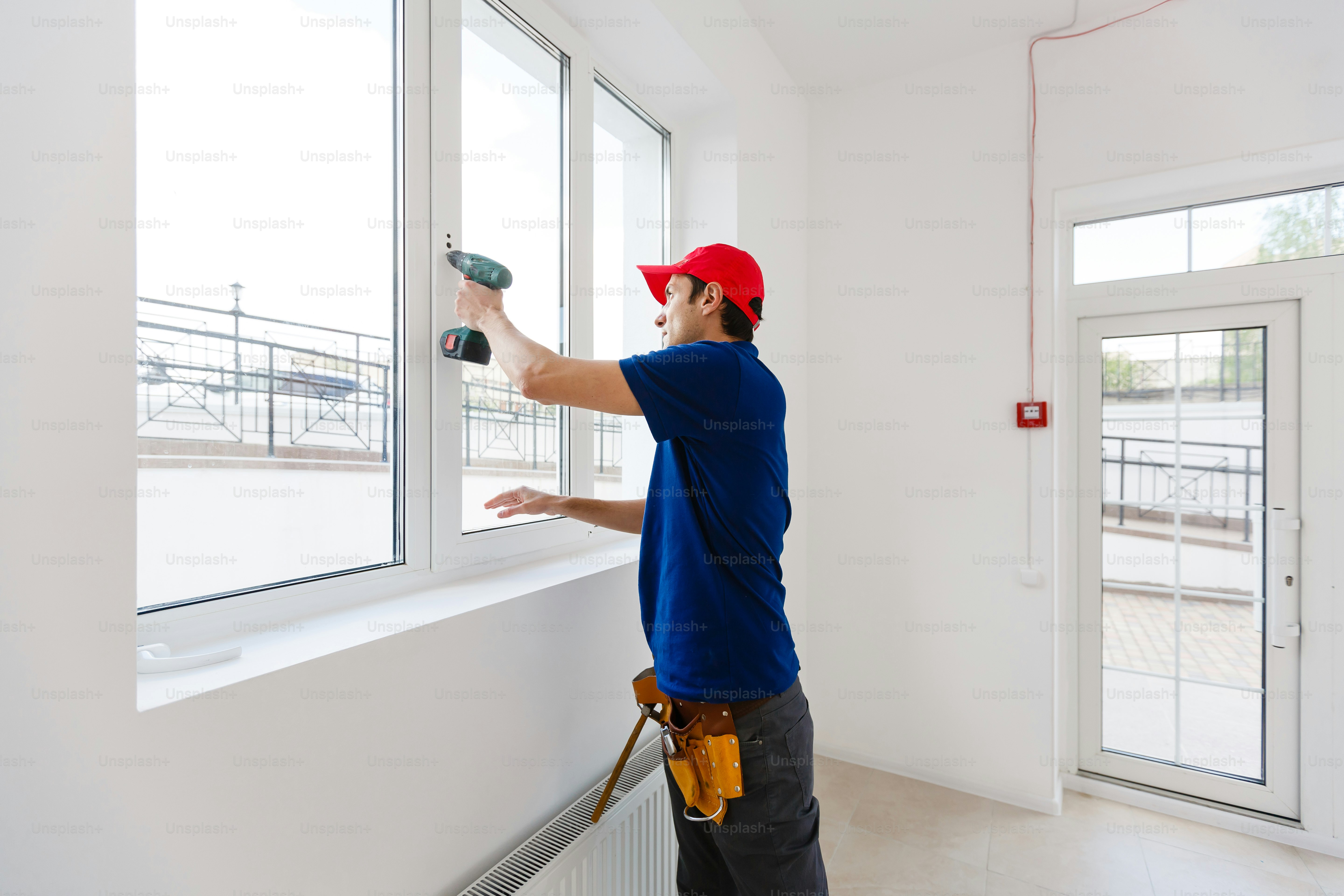 bearded adult repairman fixing window